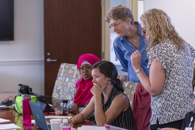 Students confer with laptop